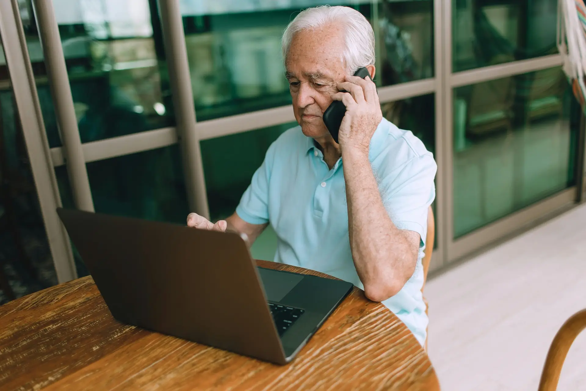 رجل مسن يتعلم استعمال الحاسوب والهاتف