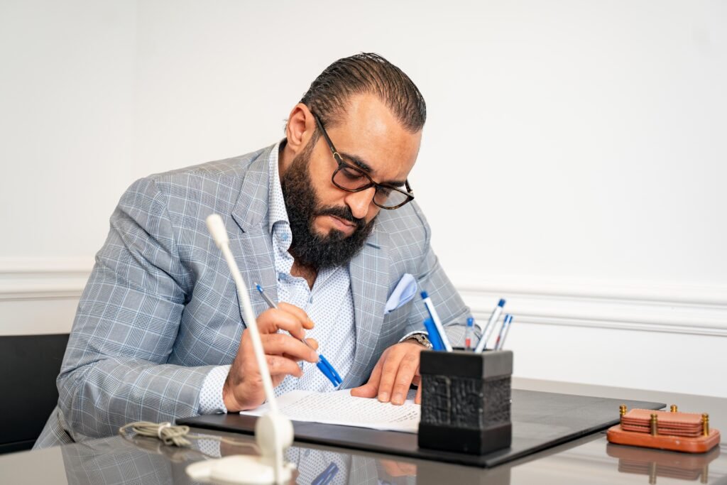 Professional bearded man in suit writing in modern office setting.